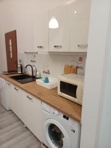 uma cozinha com uma máquina de lavar roupa e um micro-ondas em Kamienica Nowodworska 30 em Bydgoszcz