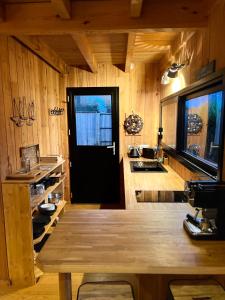 uma cozinha com paredes de madeira e uma porta preta em La cabane du Broustic em Andernos-les-Bains