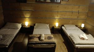 two twin beds in a room with two candles at DOM ZA STUDNIĄ Góralski dom w Ochotnicy Dolnej in Ochotnica Dolna