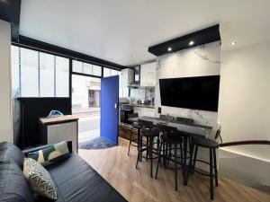 uma cozinha e sala de estar com uma mesa e um sofá em Urban Flat 172 - Pretty Flat Gaite Montparnasse Cinema em Paris