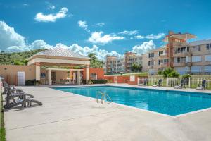 a swimming pool with chairs and a building at Ocean & Mountains View, Marina, Ferry, Vista Mar, Costa Esmeralda in Ceiba