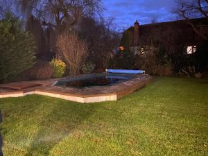 a backyard with a pool in the grass at 5-Bedroom House with a Stunning Pool, Expansive Garden, Trampoline, and Swings in Shepperton