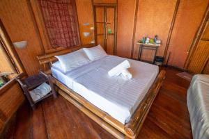 a bedroom with a bed with two towels on it at Pareehut Resort Koh Sichang in Ko Si Chang