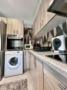 a kitchen with a washing machine and a microwave at Presidential Palace 1 in Drama