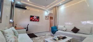 a living room with a white couch and a table at Appartement pour familles in Midelt