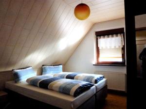 two beds in a room with a attic at Ferienwohnung am Lehnberg, Familie Richter in Neue Häuser