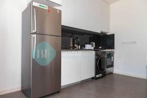 a kitchen with a stainless steel refrigerator in a room at Grandeur Studio In Pixel in Abu Dhabi