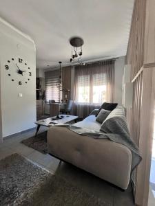 a living room with a bed and a clock on the wall at Presidential Palace 1 in Drama