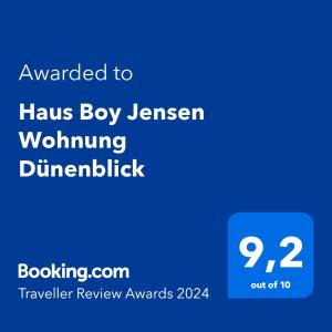 Ett certifikat, pris eller annat dokument som visas upp på Haus Boy Jensen Wohnung Dünenblick