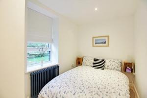 a bedroom with a bed and a window at Brook Terrace in Luddenden Foot