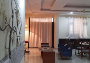 sala de estar con sofá, sillas y mesa en Elite Room - A Home Away en Jaipur