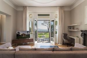 a living room with a couch and a sliding glass door at Villa Belvedere in Salò