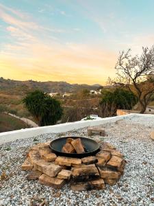 una hoguera sentada sobre una pila de madera en Romantic accommodation - Hottub & Sauna en Almogía