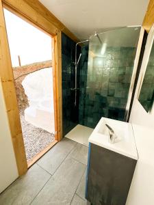 y baño con ducha y lavamanos. en Romantic accommodation - Hottub & Sauna, en Almogía