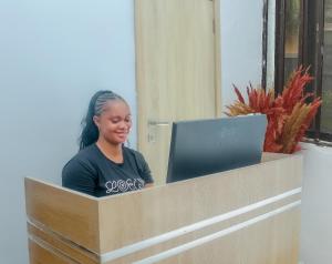 una donna seduta a una scrivania con un portatile di MORADA HOTELS LTD a Lagos