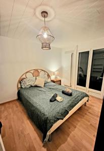 1 dormitorio con cama y lámpara de araña en Chez Le P'tit Serge, 