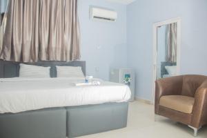 a bedroom with a bed and a chair at MORADA HOTELS LTD in Lagos