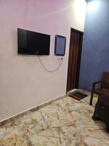 Zimmer mit einem Flachbild-TV an der Wand in der Unterkunft Shri Radha Rani Bhawan in Vrindāvan