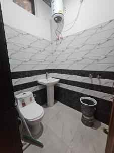 ein Bad mit einem WC und einem Waschbecken in der Unterkunft Shri Radha Rani Bhawan in Vrindāvan