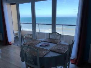 a dining room with a table and a view of the ocean at Cabourg Face A La Mer in Cabourg