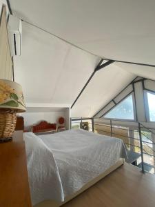 a bedroom with a white bed and a large window at Agriturismo La Locanda Del Parco in Morano Calabro