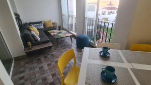 uma sala de estar com um sofá, uma mesa e cadeiras em Océan Beach em Tamaris
