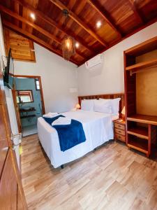 a bedroom with a white bed and a wooden floor at Espaco Villa Verde LTDA in Ibiúna