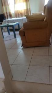 sala de estar con silla y mesa en #1 princess self catering apartments, 230mt to senegambia business strip., en Kololi