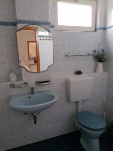 uma casa de banho com um lavatório, um WC e um espelho. em Családi apartman em Tapolca