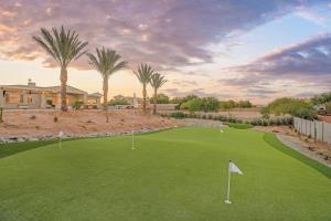 a golf course with palm trees and a house at Mountain Views, Luxury, Heated Pool, Putting Green in Rio Verde