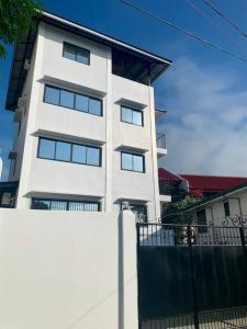 un edificio blanco con una valla delante en 4F Bohemian Apartment for 4 with Beach View en Bangcusay