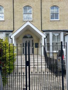 a fence in front of a house with a door at Monthly & Weekly Stays - Central London Links - Business - Relocators - Contractors in Norwood