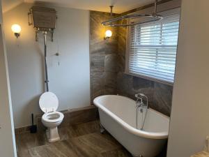 a bathroom with a tub and a toilet and a sink at Monthly & Weekly Stays - Central London Links - Business - Relocators - Contractors in Norwood
