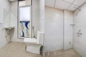 a bathroom with a toilet and a sink and a window at GAURA NITAI GUEST HOUSE in Dahmi