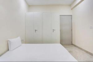 a white room with a bed and two closets at GAURA NITAI GUEST HOUSE in Dahmi