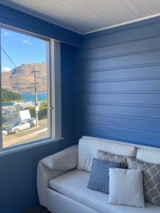 - un canapé blanc dans une chambre avec fenêtre dans l'établissement Moon House, à Queenstown