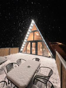 une table et des chaises sur une terrasse dans la neige dans l'établissement K2 House, à Skole