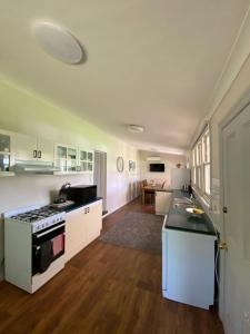a kitchen with white cabinets and a stove top oven at Somerby! in Albury