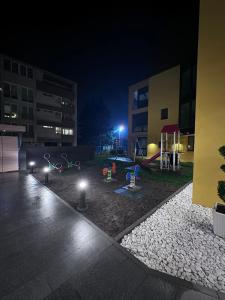 a park at night with a playground in a building at Pannonica Apartman B in Tuzla