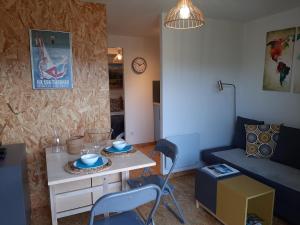 CHALET la VEILLA في آكس ليه تيرم: غرفة معيشة صغيرة مع طاولة وكراسي