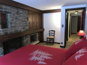een slaapkamer met een rood bed en een open haard bij Grangettes in Les Carroz d'Araches