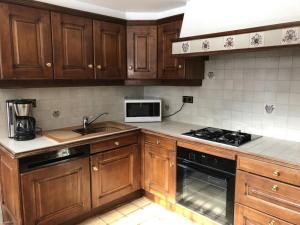 een keuken met houten kasten en een fornuis met oven bij Grangettes in Les Carroz d'Araches