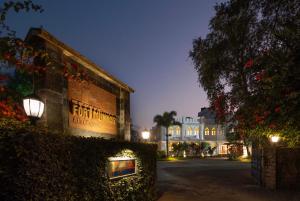 a building with a sign on the side of it at night at Fort Munnar in Chinnakanal