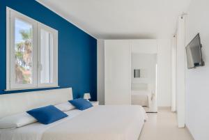 a bedroom with a white bed with blue walls at DolceVitaSuites - Modern 3 Bdr Villa in S. Lorenzo in San Lorenzo +49 photos