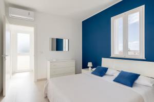 a bedroom with blue walls and a bed with blue pillows at DolceVitaSuites - Modern 3 Bdr Villa in S. Lorenzo in San Lorenzo