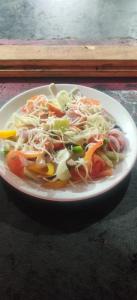 um prato branco de comida numa mesa em Laughing Buddha hampi guest House em New Hampi