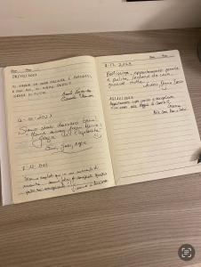 two notebooks with writing on them on a table at La casa di Ele 2-100 metri dalla Reggia in Caserta