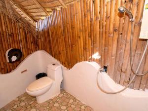 a bathroom with a toilet and a wooden wall at Pareehut Resort Koh Sichang in Ko Si Chang