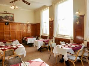 a dining room with tables and chairs with white tablecloths at The Star Hotel in Southampton