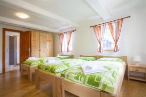 a bedroom with two beds with green comforter at Penzion U Vyhlídky in Chřibská